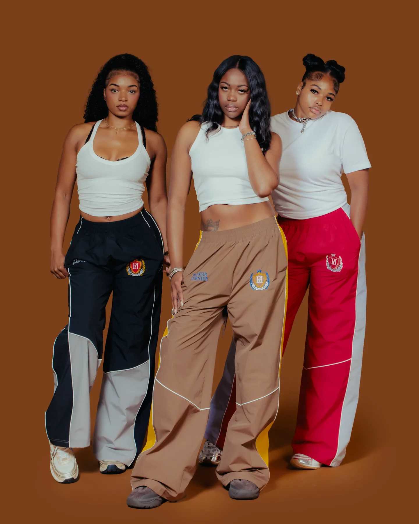 Campaign cast wearing the black, brown and red track pants